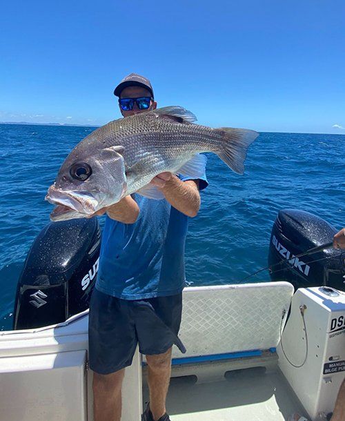 Happy Man Holding a Big Fish  Caught on Fishing Charters Sunshine Coast