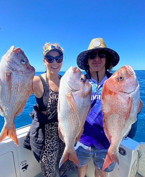 Couple Holding Large Fish Together They Caught from Fishing Charters on the Sunshine Coast QLD