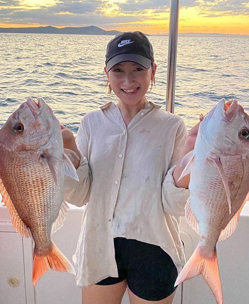 Young Lady Holding Two Fresh Fish She Caught from Deep Sea Fishing | Fishing Charters Sunshine Coast