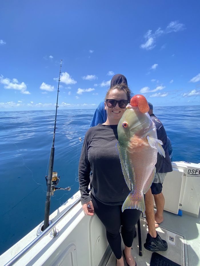Woman Happily Holding Fish She Caught on the Deep Sea Fishing Charters Sunshine Coast