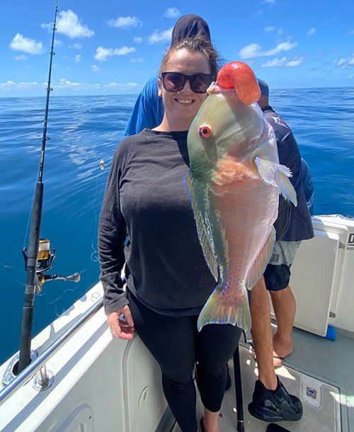 Woman Holding Up a Parrot Fish She Caught | Fishing Charters Sunshine Coast QLD