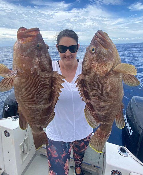 Woman Holding 2 Cod Fish on the Yacht | Fishing Charters Sunshine Coast