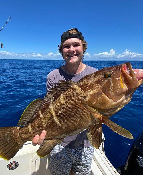 Man Smiling While Holding Greasy Cod Fish  Caught from Deep Sea Fishing | Fishing Charters Sunshine Coast