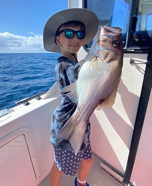Kid with a Fish on the Charter Yacht | Fishing Charters Sunshine Coast