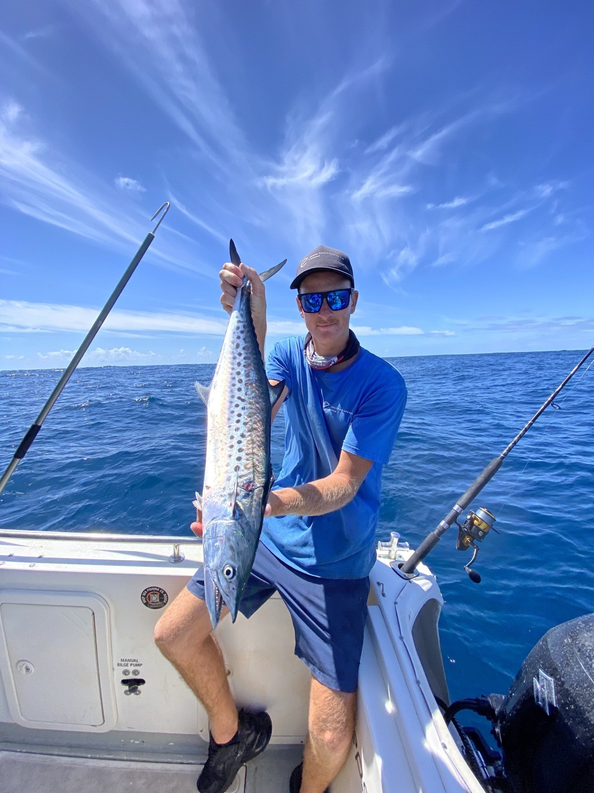 A man is sitting on a boat holding a large fish.