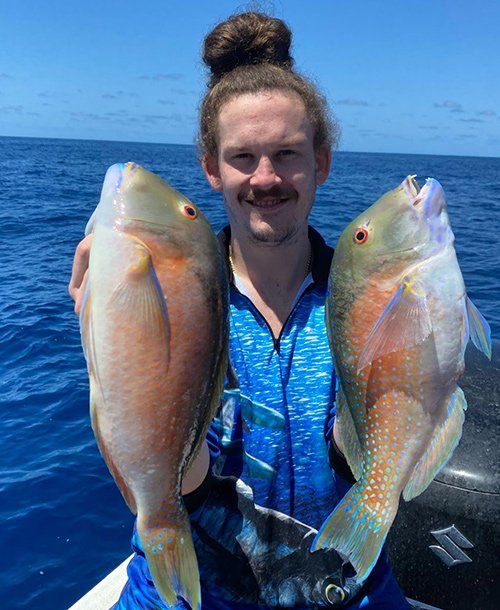 Man Happily  Holding Twin Parrot Fish  He Caught on Fishing Charters Sunshine Coast QLD