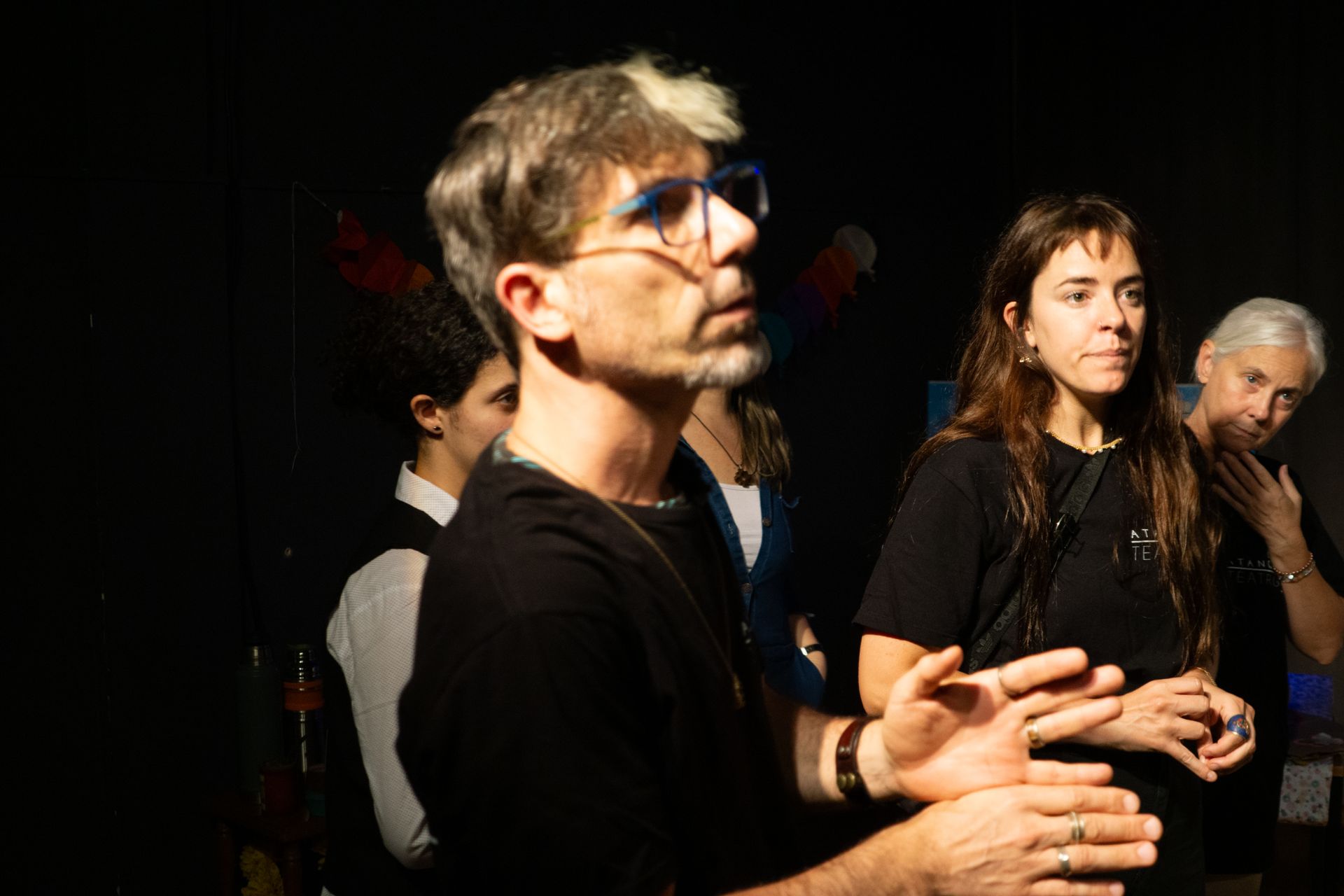 Un hombre y una mujer están parados uno al lado del otro en una habitación oscura.