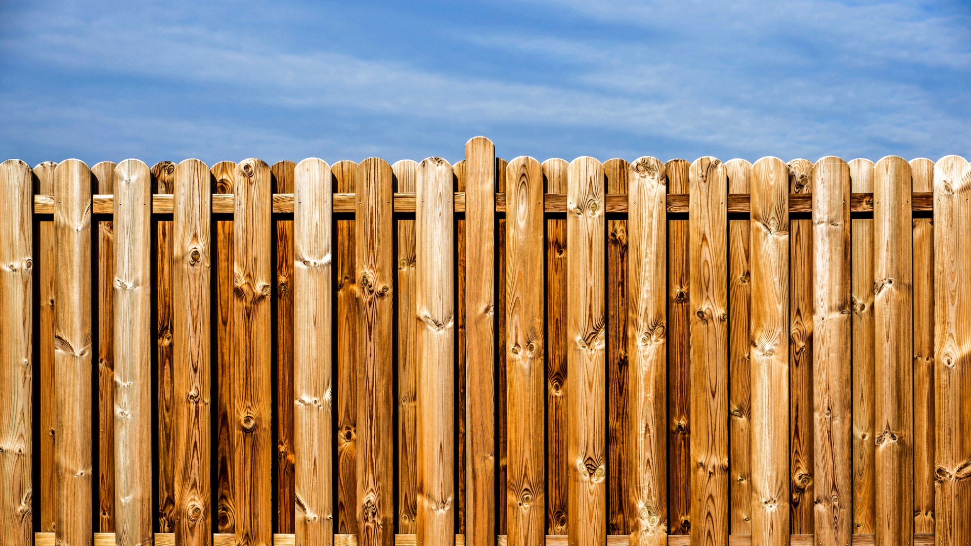 Wooden fence against a blue sky.