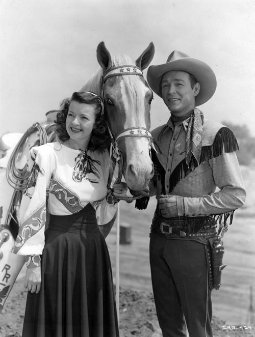 A man and a woman standing next to a horse