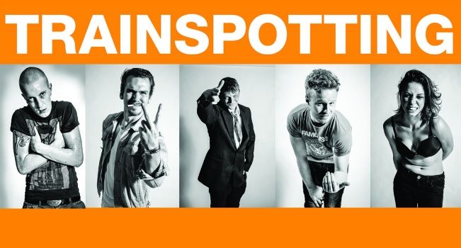 A group of people are standing in front of a sign that says trainspotting