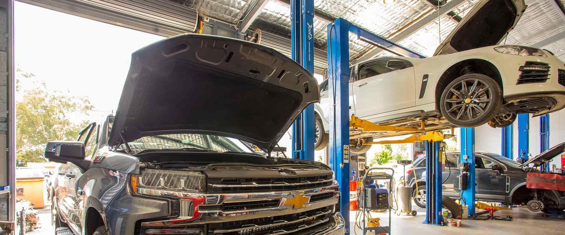 A Truck and a Sports Car Are on a Lift in a Garage — Gricey's Workshop Automotive Specialist in West Wodonga, VIC