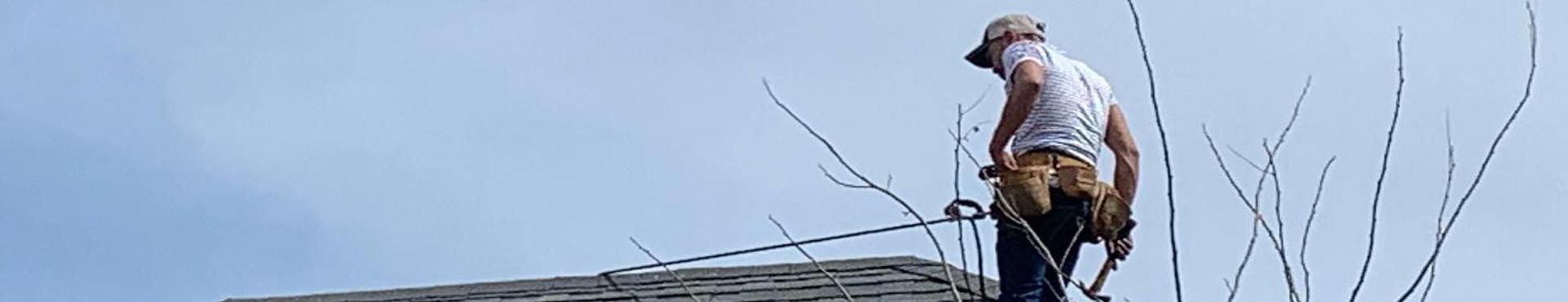 A man is standing on top of a barbed wire fence.