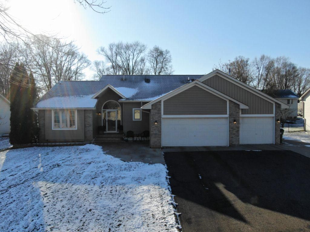 A house with two garages and a snowy driveway