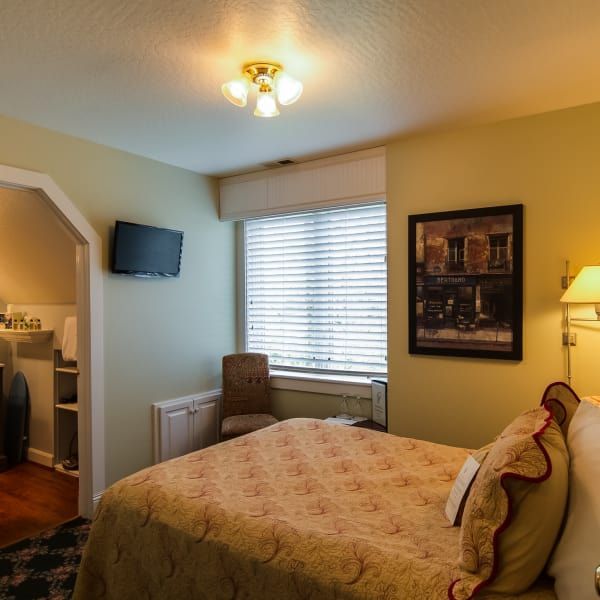 A bedroom with a large bed and a picture on the wall