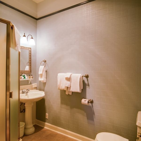 A bathroom with a sink toilet and mirror