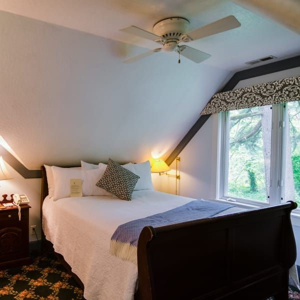 A bedroom with a sleigh bed and a ceiling fan