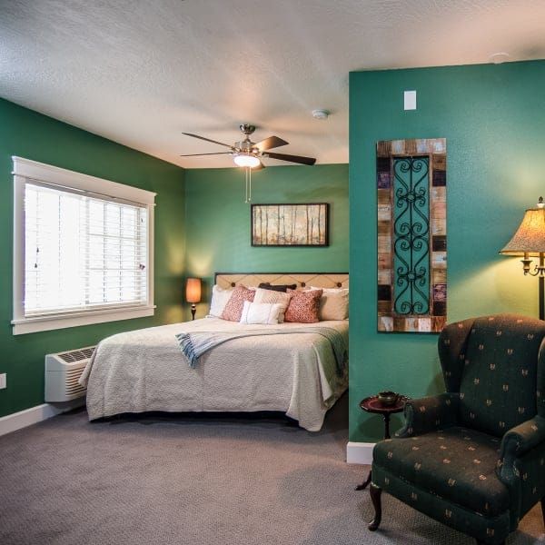 A bedroom with green walls and a large bed