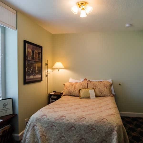 A bedroom with a bed and a picture on the wall