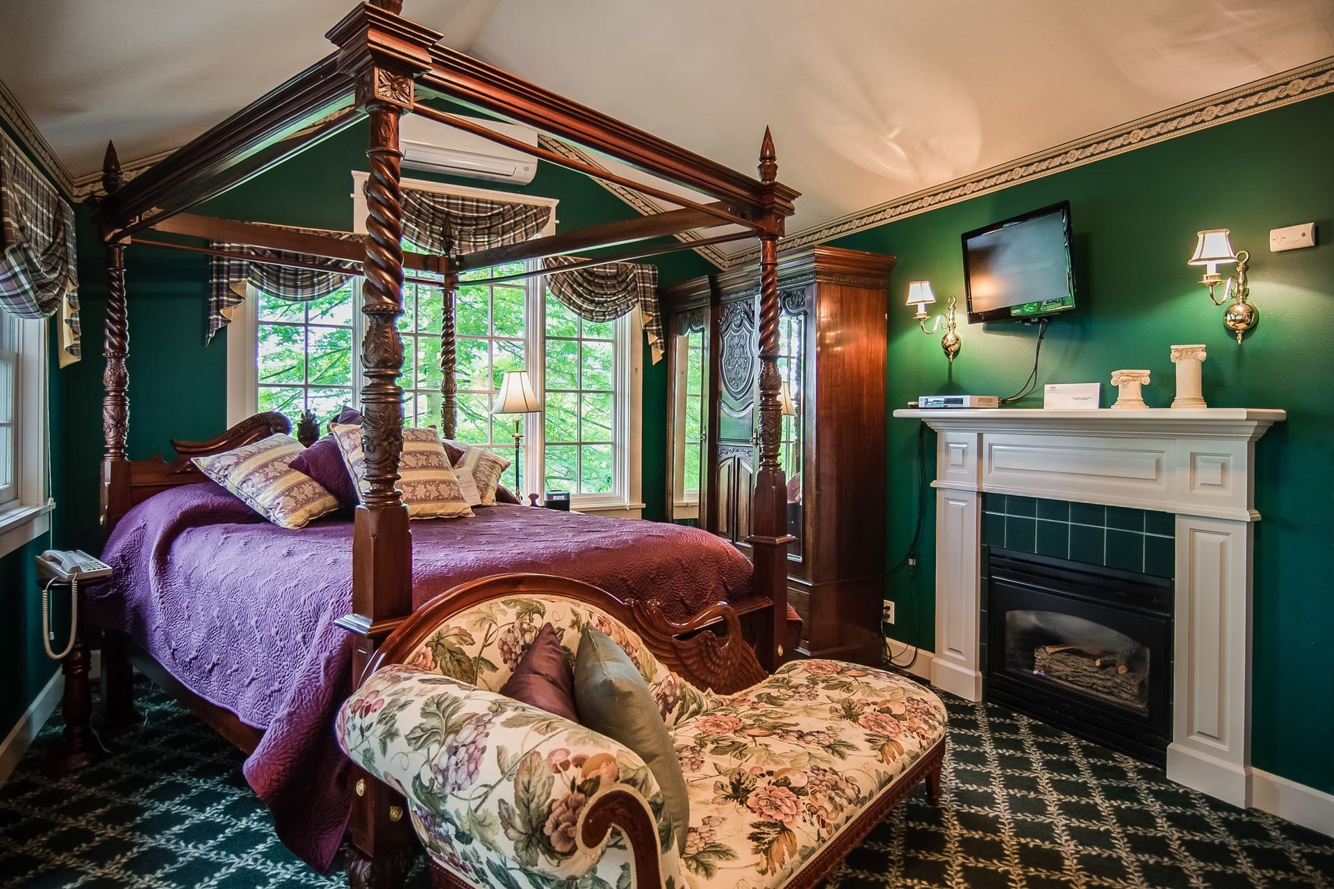 A bedroom with a four poster bed and a fireplace.