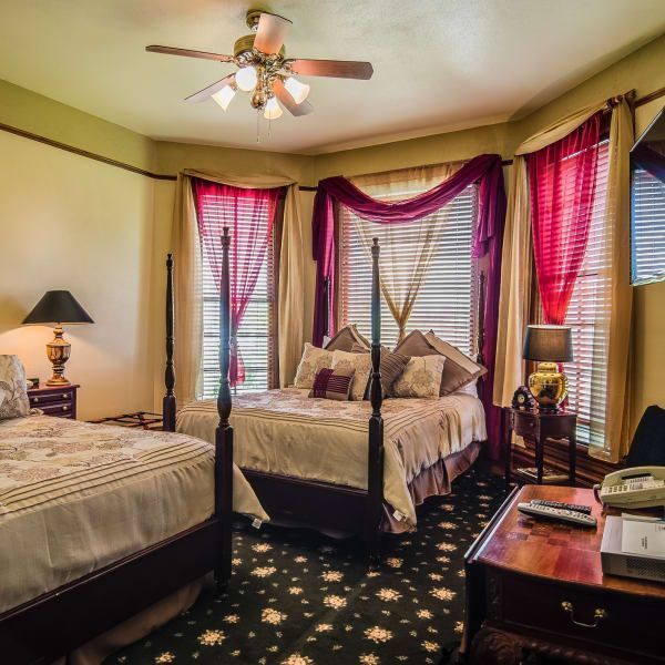 A bedroom with two beds and a ceiling fan