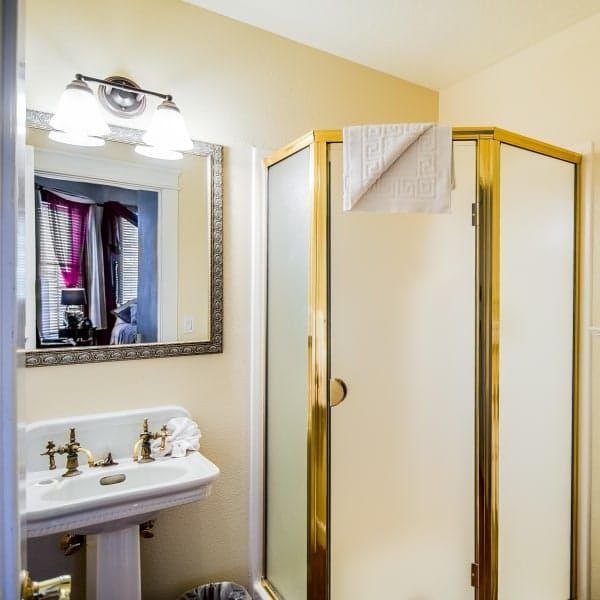 A bathroom with a sink and a shower stall