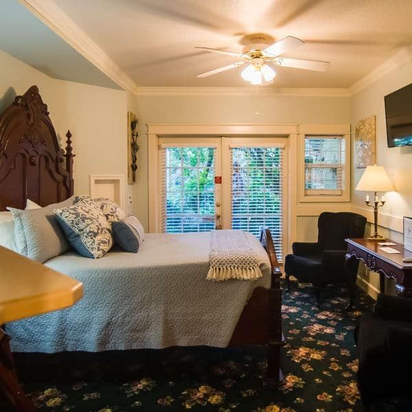 A bedroom with a large bed and a ceiling fan