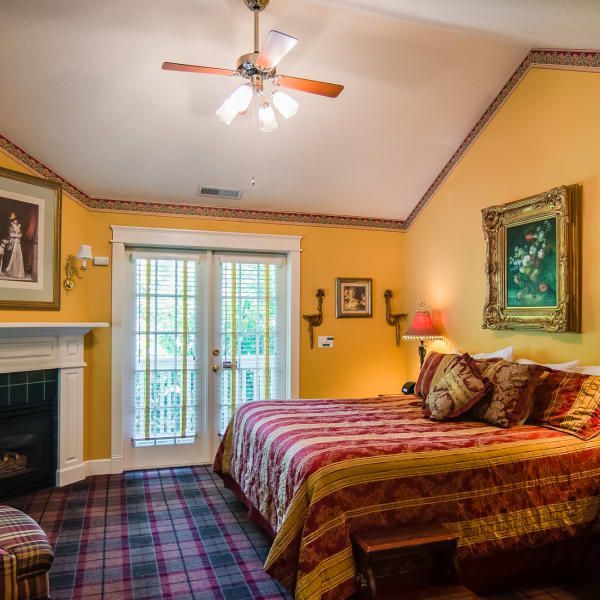 A bedroom with a large bed and a ceiling fan