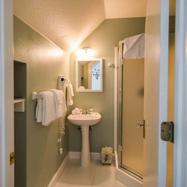 A bathroom with a sink a mirror and a shower