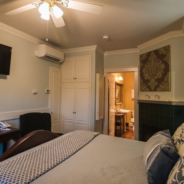 A bedroom with a large bed and a ceiling fan