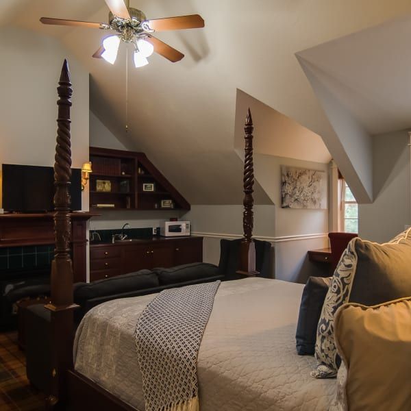 A bedroom with a four post bed and a ceiling fan