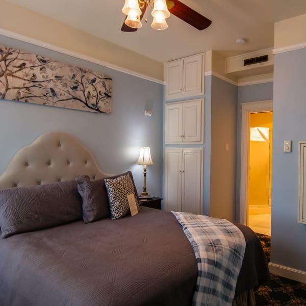 A bedroom with a bed and a ceiling fan