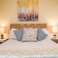 There is a painting on the wall above the bed.