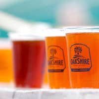 Three cups of beer are sitting on a table.