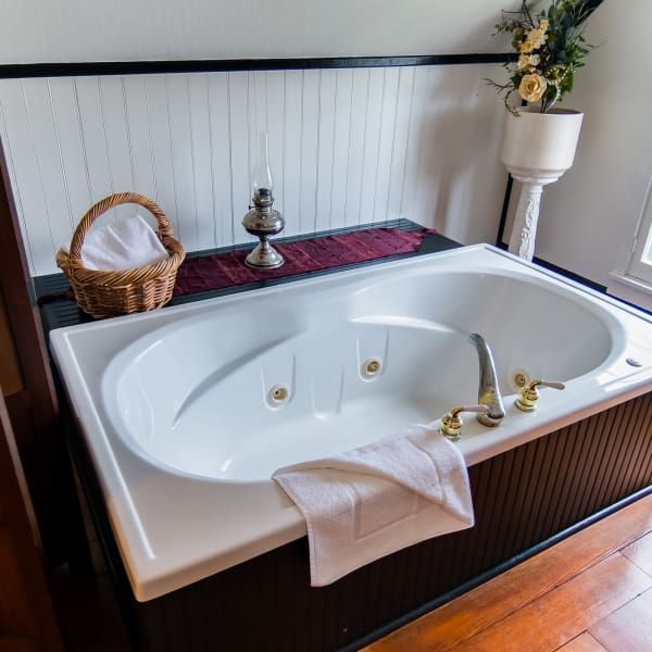 A bathtub in a bathroom with a basket on top of it