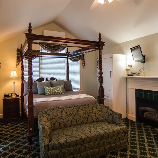 A bedroom with a canopy bed and a couch