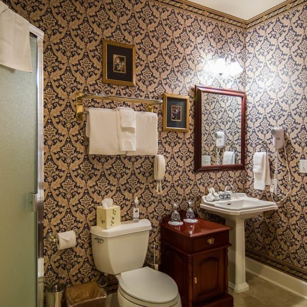 A bathroom with a toilet a sink and a mirror