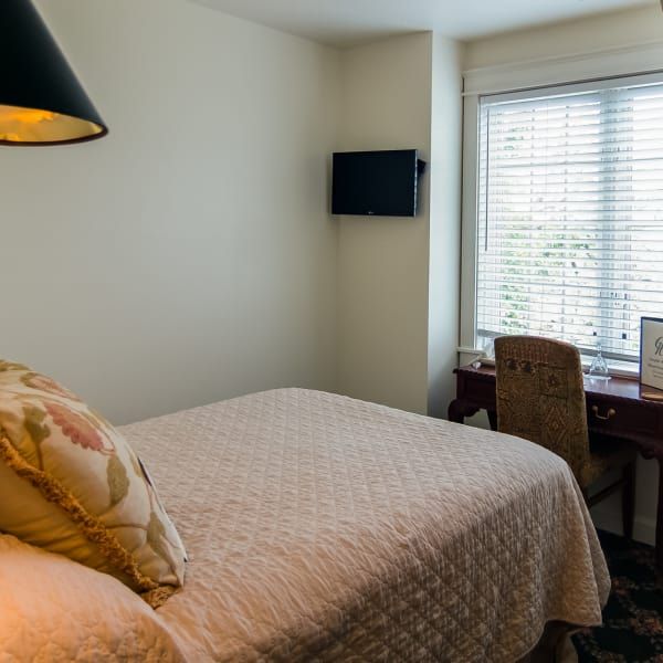 A bedroom with a large bed and a desk