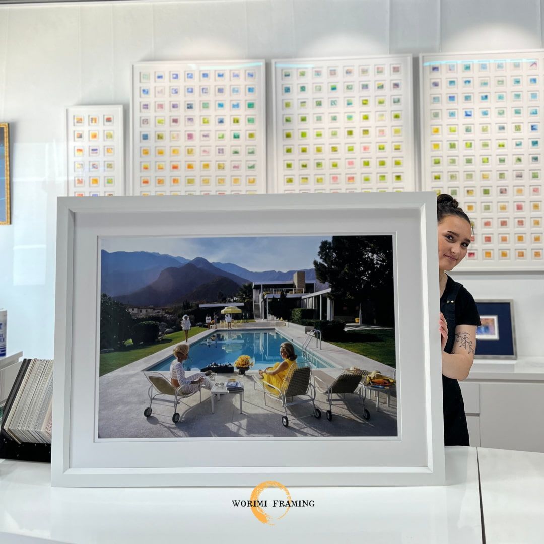 A Woman Is Standing In Front Of A Framed Picture Of A Pool — Worimi Framing Service In Adamstown, NSW