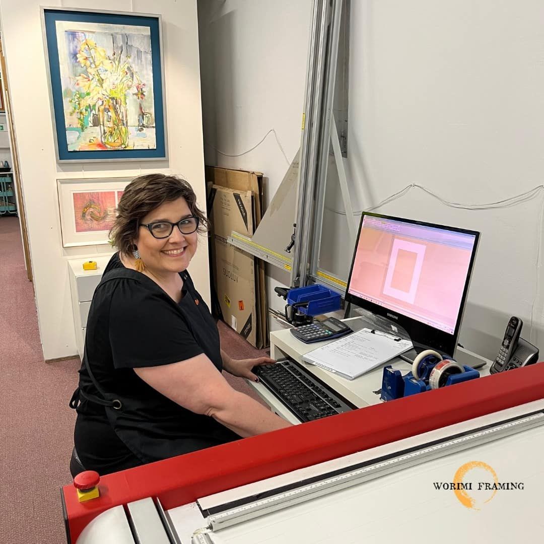 A Woman Is Sitting At A Desk In Front Of A Computer — Worimi Framing Service In Central Coast, NSW