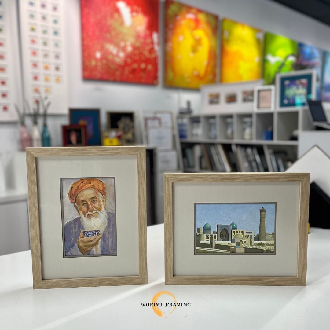 Two Framed Pictures Are Sitting On A Table In A Room — Worimi Framing Service In Lake Macquarie, NSW