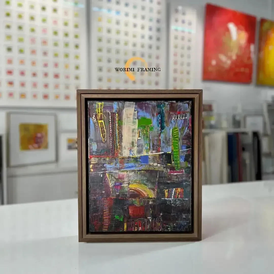 A Framed Painting Is Sitting On A Table In A Room — Worimi Framing Service In Lake Macquarie, NSW
