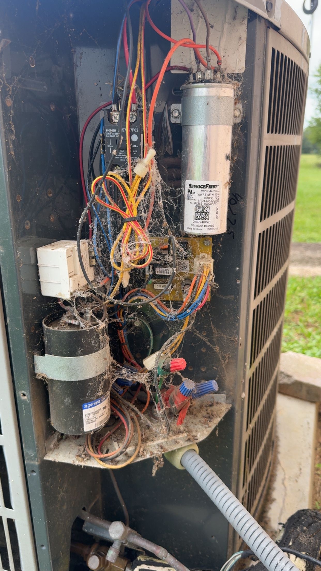 Air conditioning unit are covered in cobwebs and showing signs of damage.