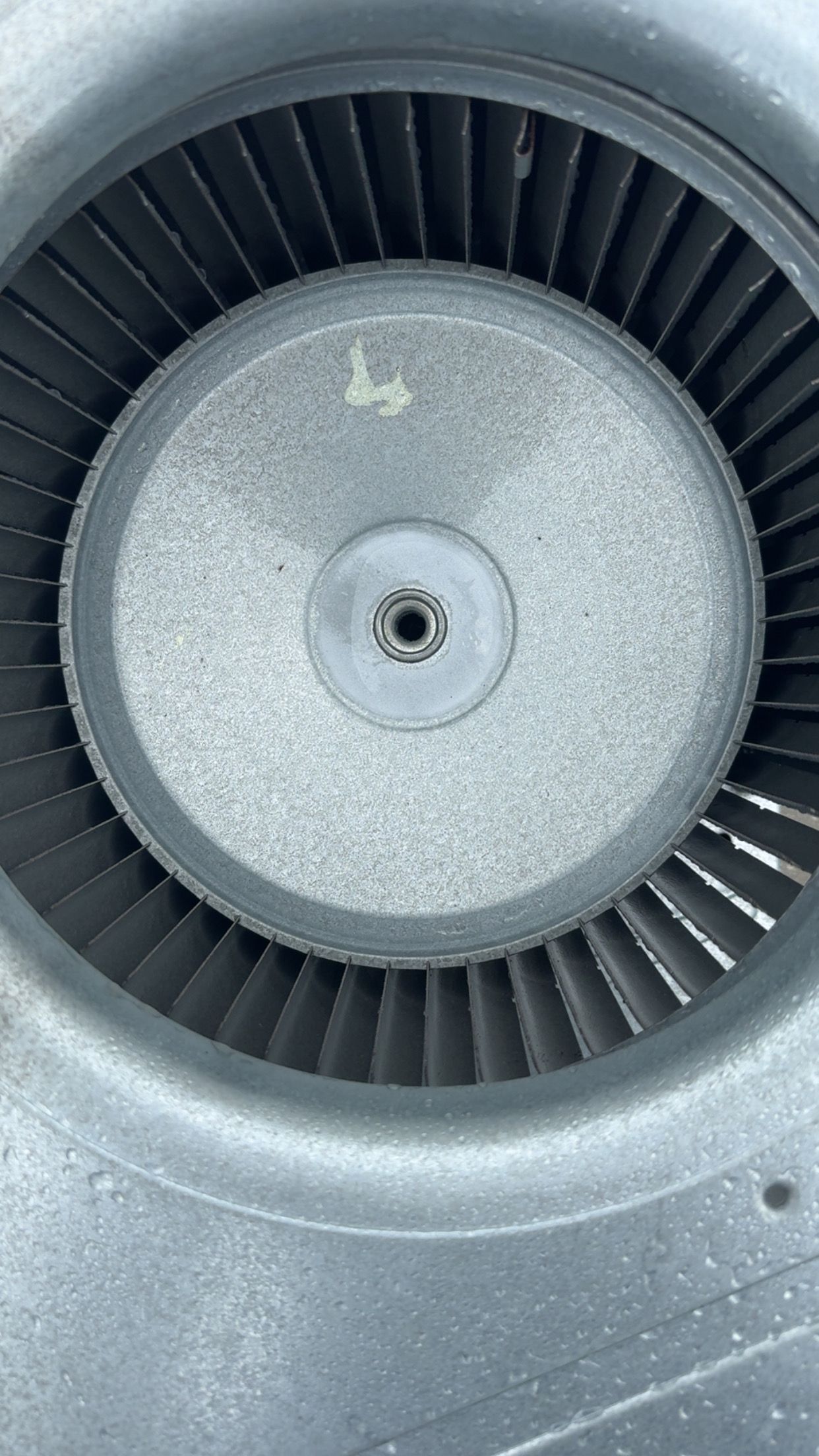 Close-up of a blower wheel inside a metallic housing.