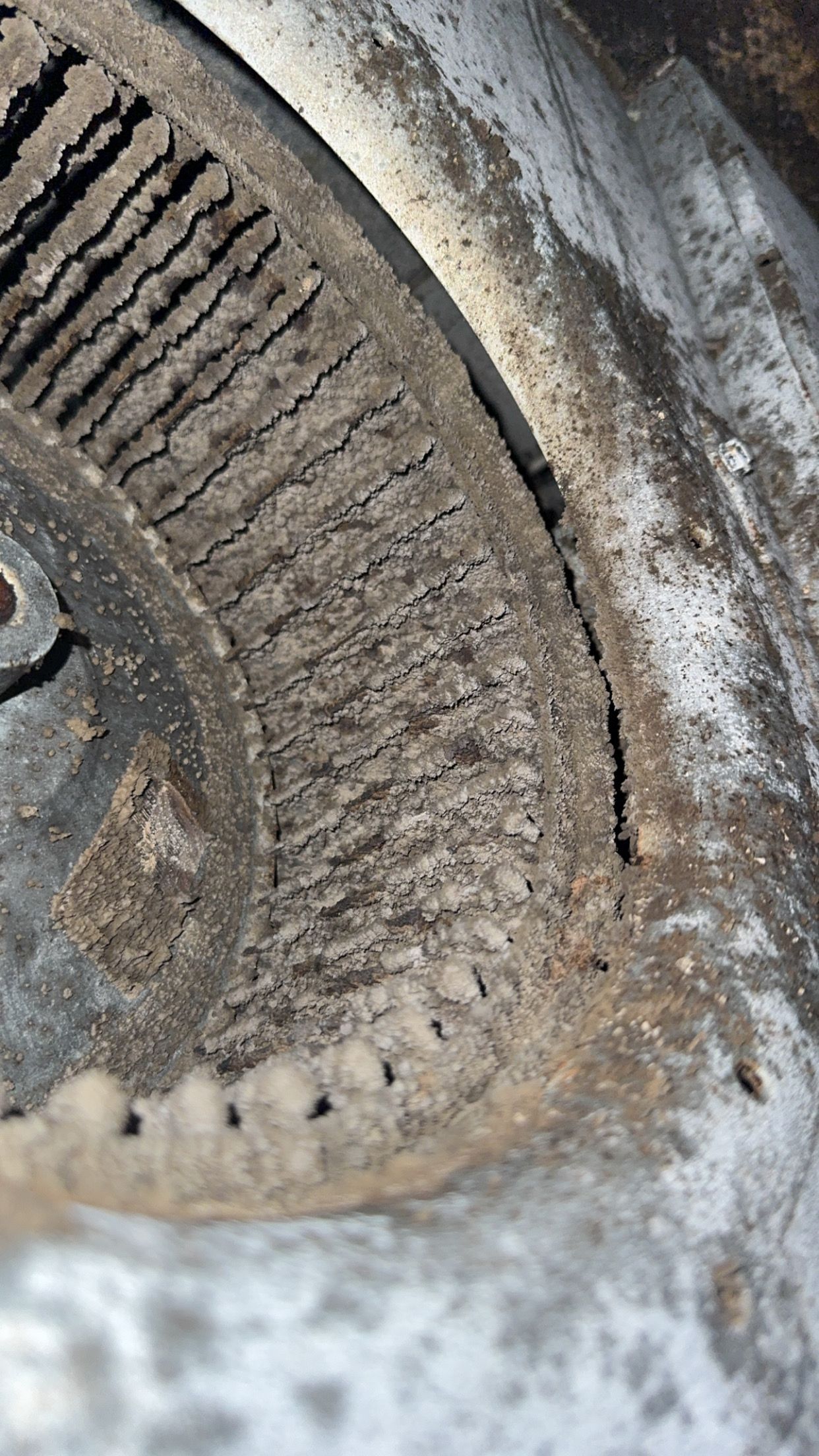 Dirty, dusty air conditioning vent with visible fins and debris buildup.