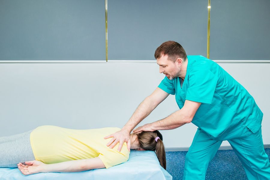 A Man is Giving a Woman a Massage on a Bed — Mark O'Brien Chiropractic in West End, QLD
