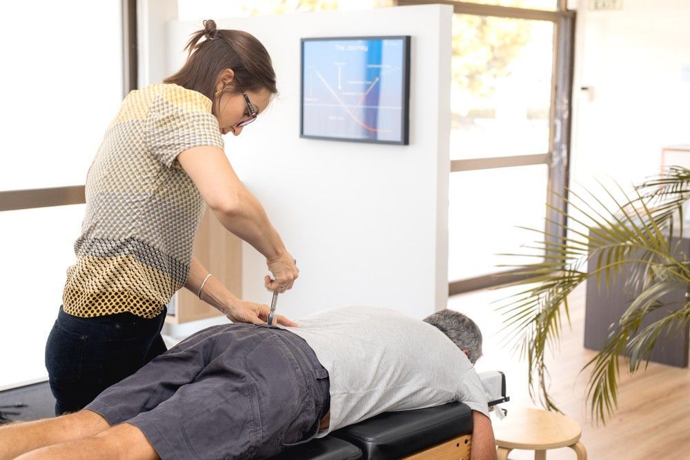 A Woman is Giving a Man a Massage on a Table — Mark O'Brien Chiropractic in West End, QLD