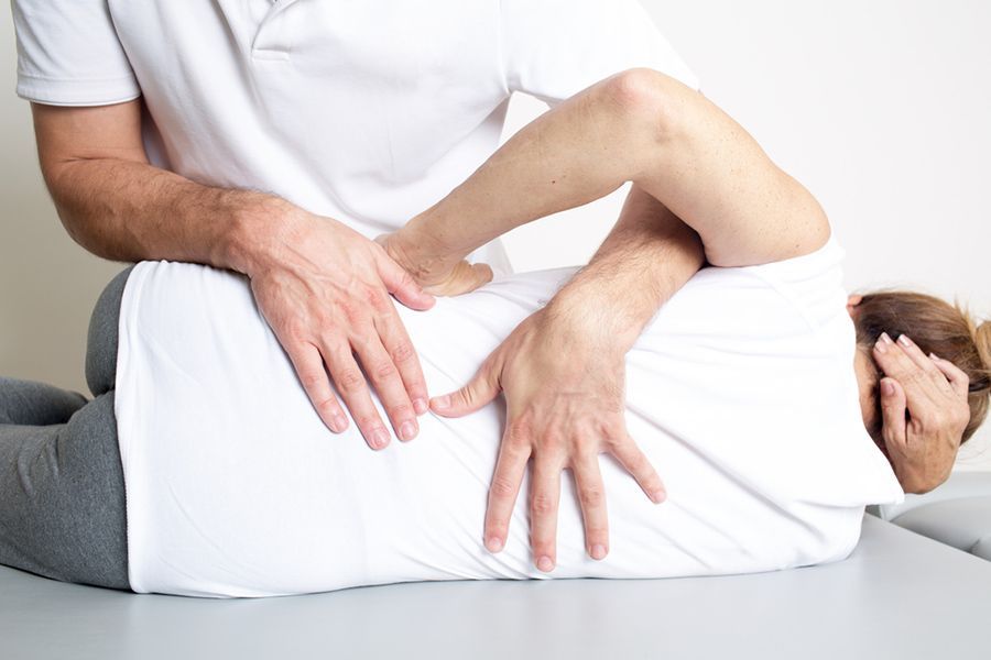 A Man is Giving a Woman a Massage on Her Back — Mark O'Brien Chiropractic in West End, QLD