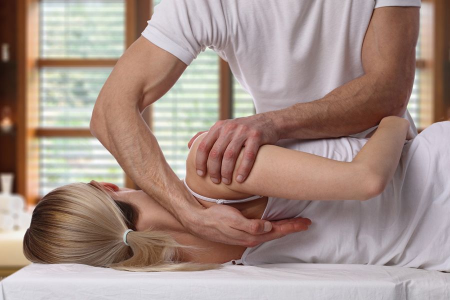 A Man is Giving a Woman a Massage on a Table — Mark O'Brien Chiropractic in West End, QLD