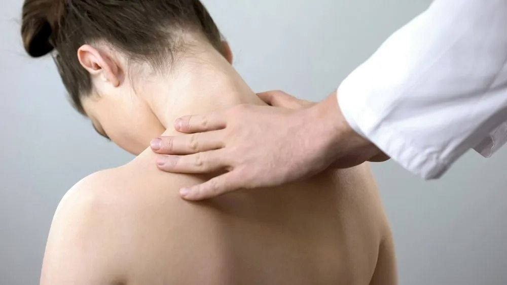 A Woman is Getting a Neck Massage From a Doctor — Mark O'Brien Chiropractic in West End, QLD