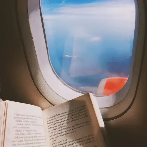 An Open Book is Sitting in Front of an Airplane Window  — Mark O'Brien Chiropractic in West End, QLD